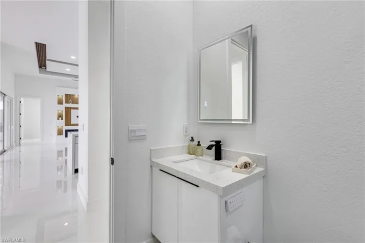 Bathroom with vanity and a textured wall