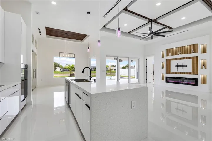 Kitchen featuring modern cabinets, white cabinets, pendant lighting, light stone countertops, and light tile patterned flooring