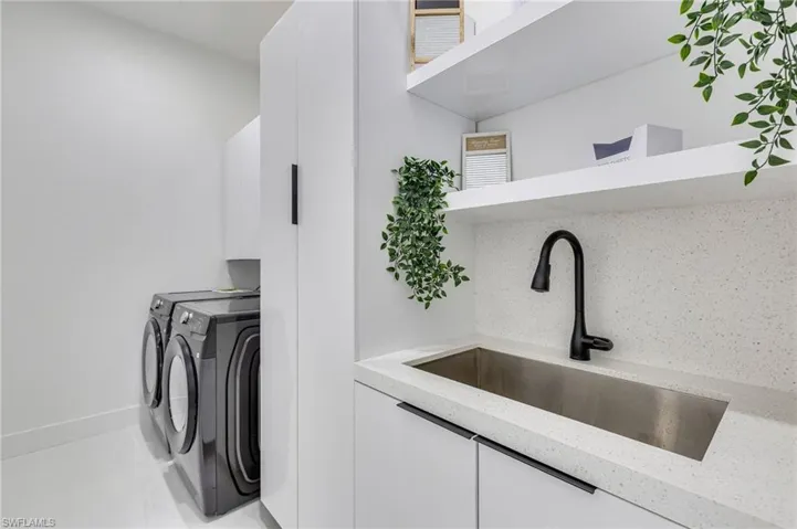 Laundry room featuring cabinet space, washing machine and dryer, and tile patterned flooring