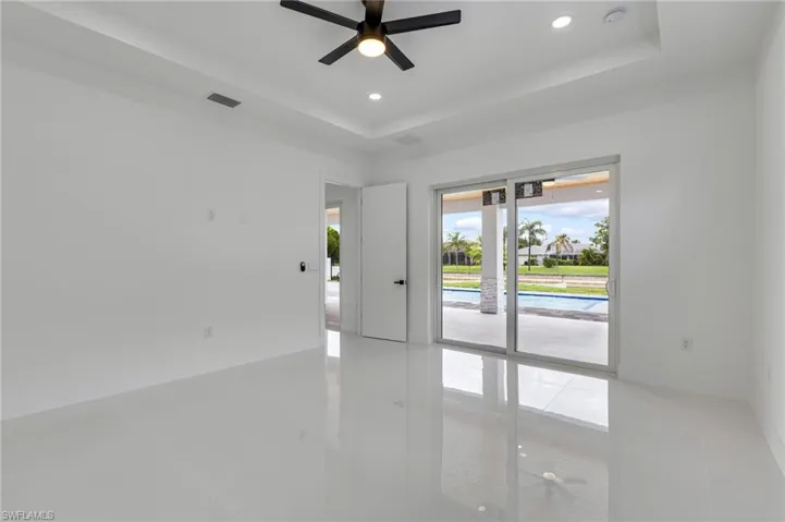 Unfurnished room featuring a raised ceiling, recessed lighting, and ceiling fan