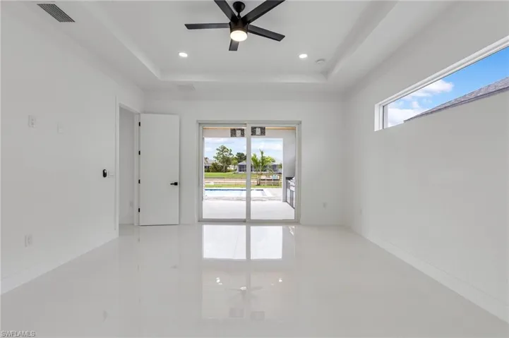 Unfurnished room with a raised ceiling, ceiling fan, recessed lighting, and light tile patterned floors