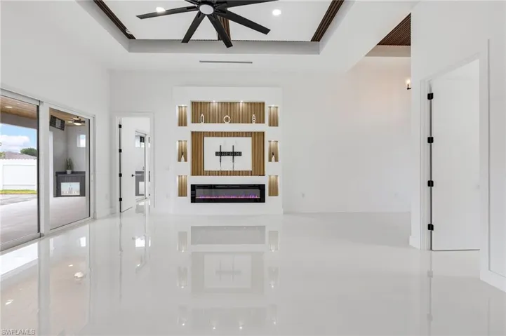 Hallway with a tray ceiling, tile patterned flooring, and recessed lighting