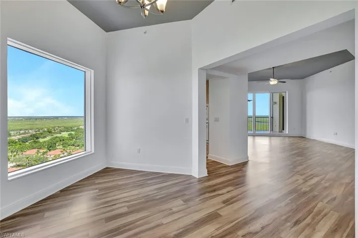 Empty room featuring wood finished floors, a chandelier, and a ceiling fan