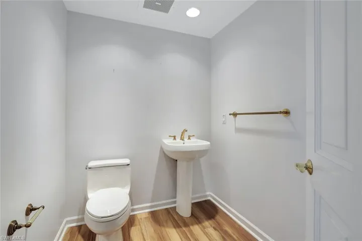 Half bath with light wood-style floors and recessed lighting
