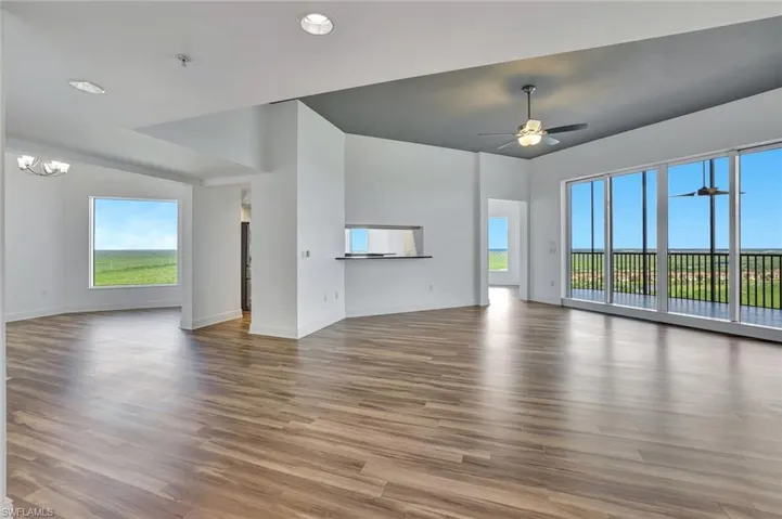 Unfurnished living room featuring wood finished floors, healthy amount of natural light, recessed lighting, and a ceiling fan