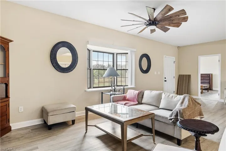Living room with ceiling fan and light hardwood / wood-style flooring