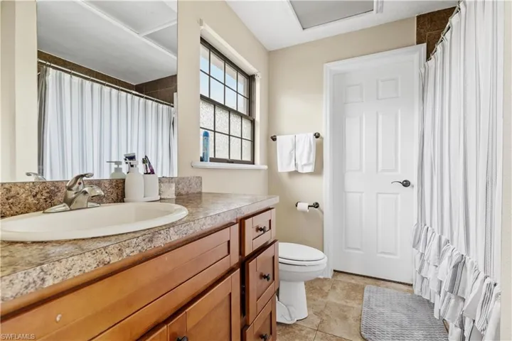 Bathroom featuring tile patterned flooring, vanity, and toilet