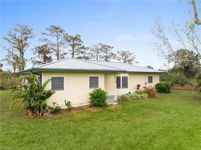 Back of property with a lawn