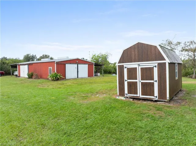 View of outdoor structure featuring a lawn