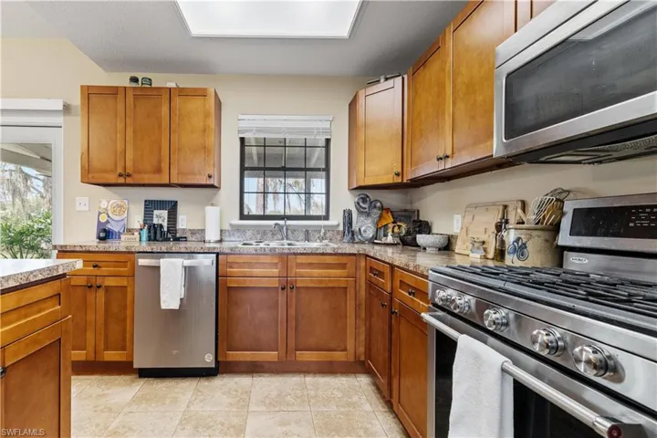 Kitchen featuring sink, light tile patterned floors, and stainless steel appliances