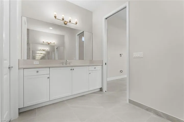 Primary bathroom 2nd vanity featuring a wide vanity with white cabinetry, a light, quartz countertop, and a large mirror.