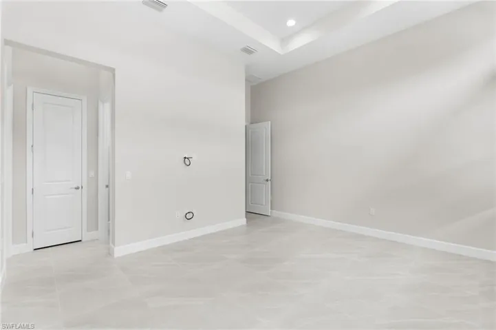 Primary suite with 2 walk-in closets, coffered ceiling, transom windows.