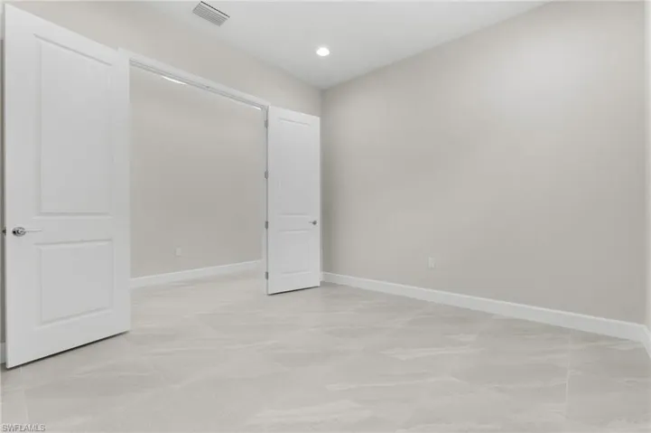 Large den area with double doors, recessed lighting.