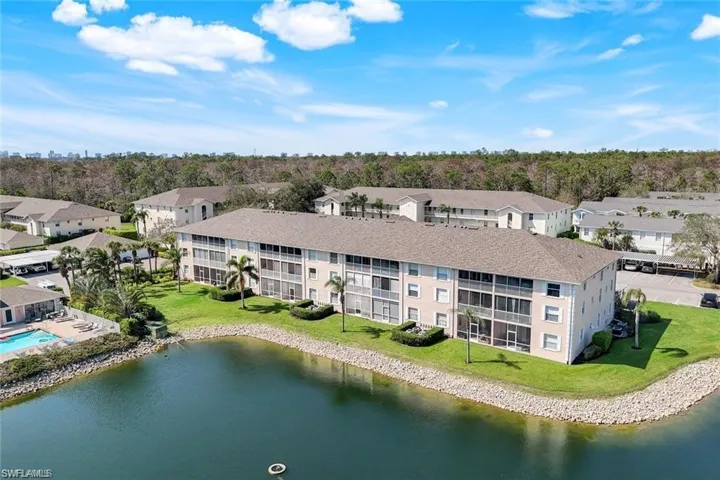 Drone / aerial view of a nearby body of water and apartment complex / building