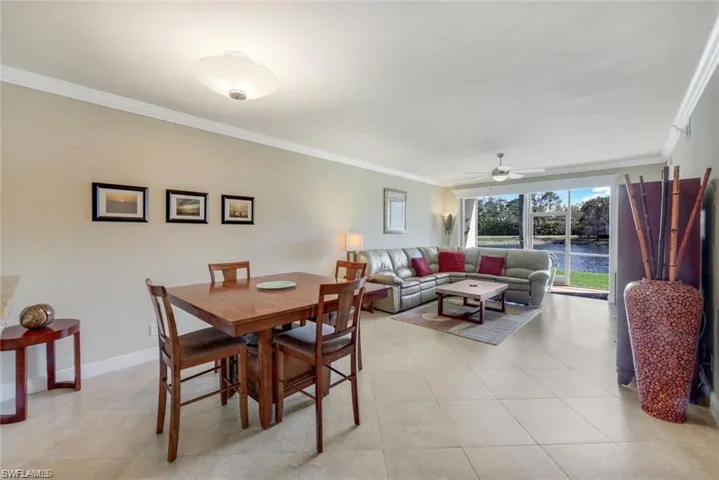 Dining space with ornamental molding, ceiling fan, and light tile patterned floors