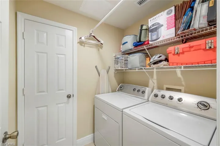 Laundry room featuring washer and dryer and baseboards