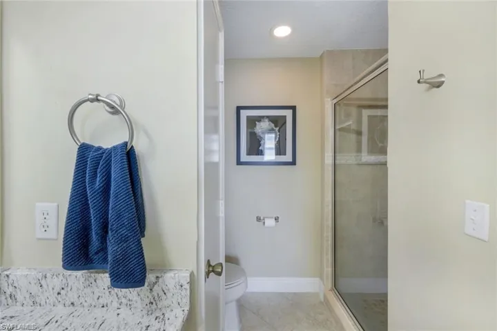 Bathroom featuring a shower stall and light tile patterned floors