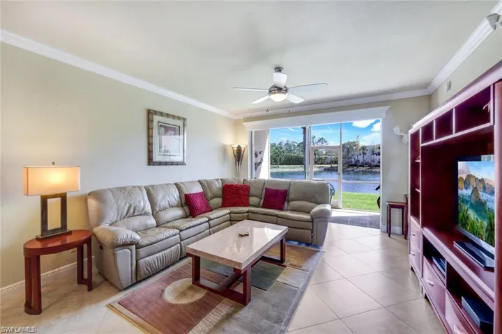Living area featuring ornamental molding, a ceiling fan, and light tile patterned floors
