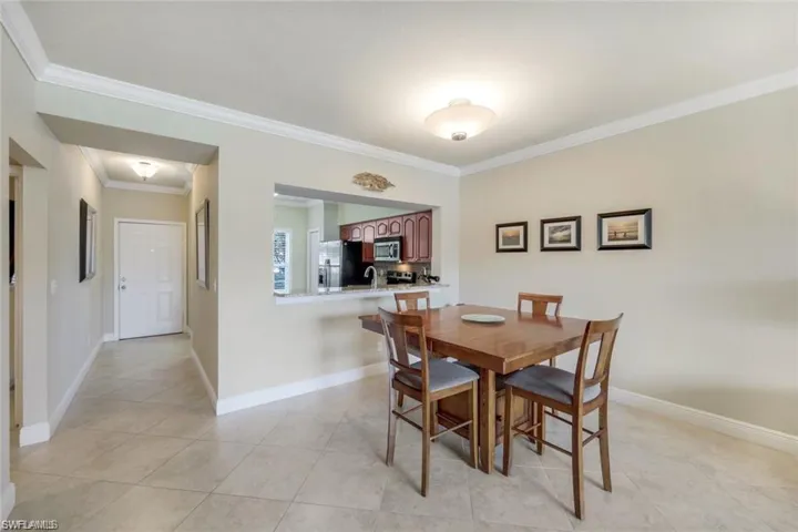Dining space with ornamental molding and light tile patterned floors