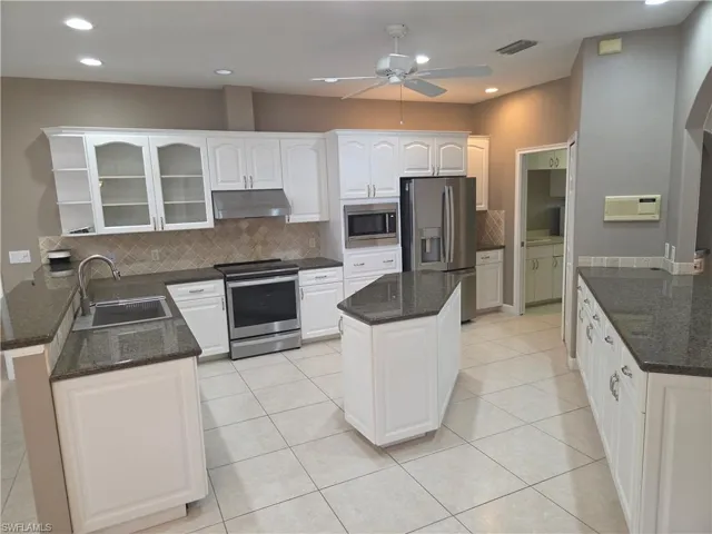 Kitchen featuring stainless steel appliances, ceiling fan, under cabinet range hood, recessed lighting, and white cabinetry