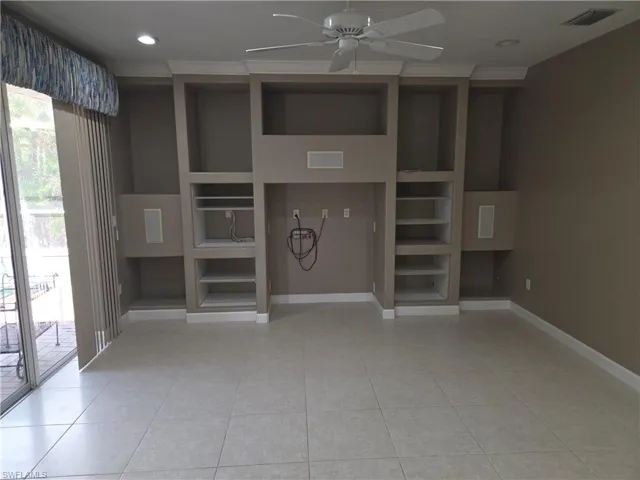 Unfurnished living room with built in shelves, a ceiling fan, light tile patterned floors, ornamental molding, and recessed lighting