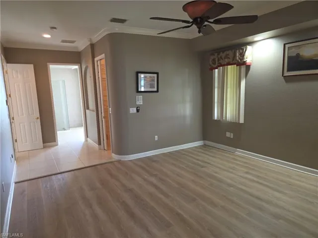 Empty room with crown molding, ceiling fan, wood finished floors, and recessed lighting