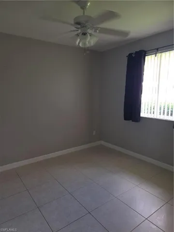 Unfurnished room featuring ceiling fan and light tile patterned floors