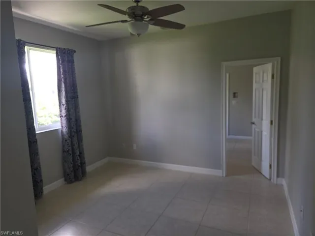 Unfurnished room with a ceiling fan and tile patterned floors