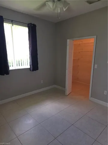 Unfurnished bedroom featuring light tile patterned floors and a ceiling fan