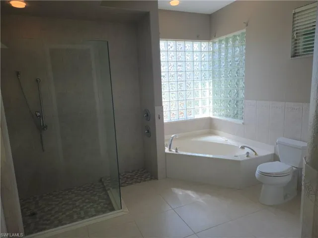 Bathroom featuring a garden tub, tile patterned flooring, and a stall shower