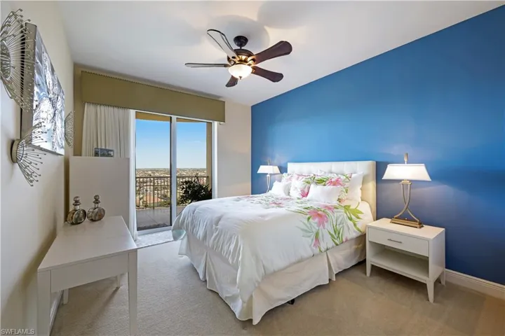 Carpeted bedroom with ceiling fan and access to exterior