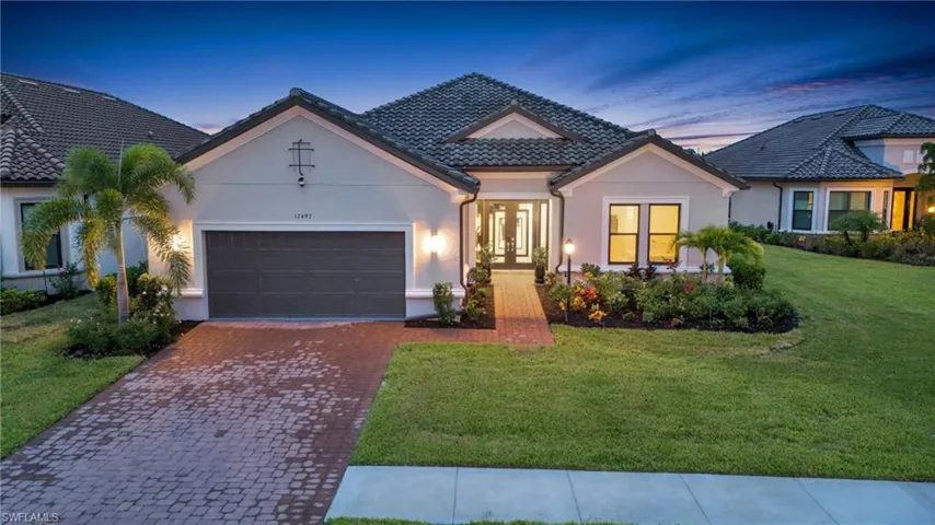 View of front of home with a garage and a yard