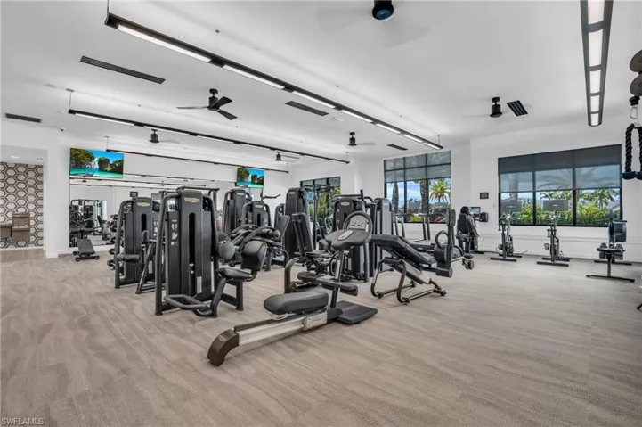 Exercise room featuring light carpet and ceiling fan