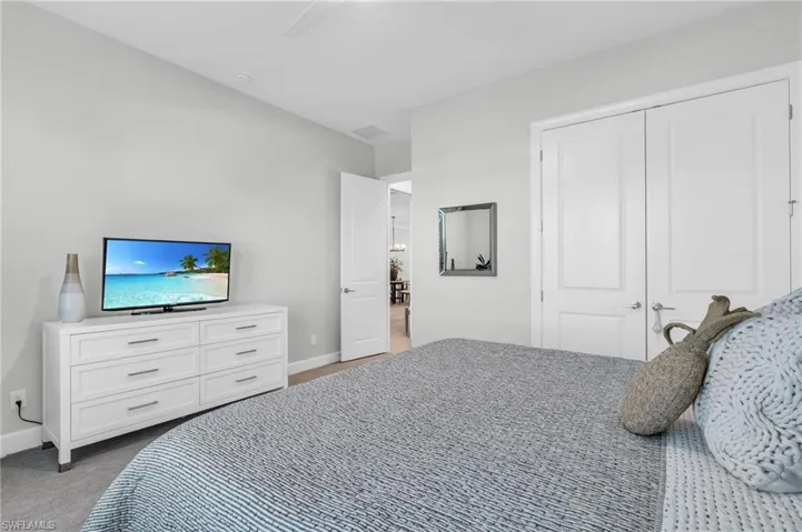 Bedroom with ceiling fan, a closet, and carpet