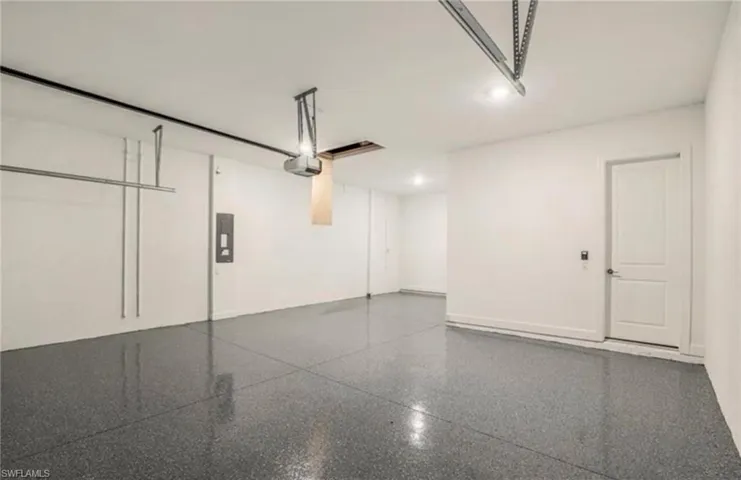 Garage featuring a garage door opener and electric panel