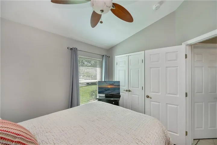 Bedroom featuring vaulted ceiling, a closet, and a ceiling fan