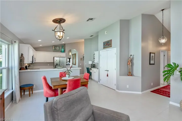 Dining space with high vaulted ceiling, arched walkways, and recessed lighting