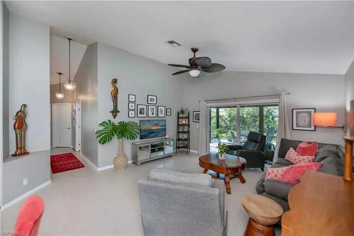 Tiled living area with high vaulted ceiling and a ceiling fan