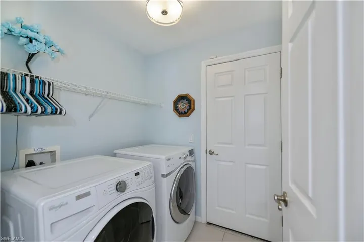 Washroom featuring separate washer and dryer and light tile patterned floors