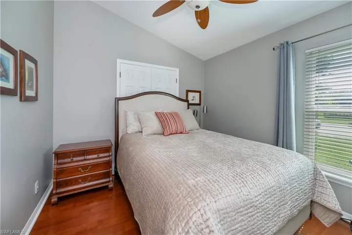 Bedroom featuring wood finished floors, lofted ceiling, and ceiling fan