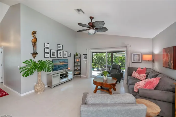 Living area featuring lofted ceiling, a ceiling fan, and light tile patterned floors