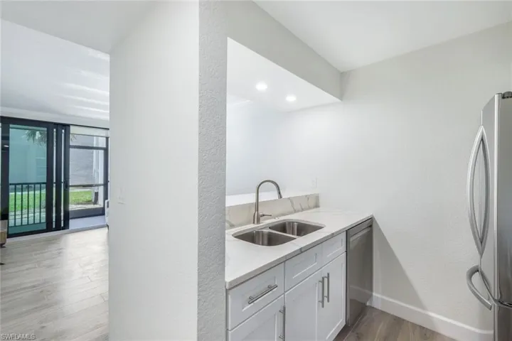 Kitchen with appliances with stainless steel finishes, light wood-style flooring, and white cabinets