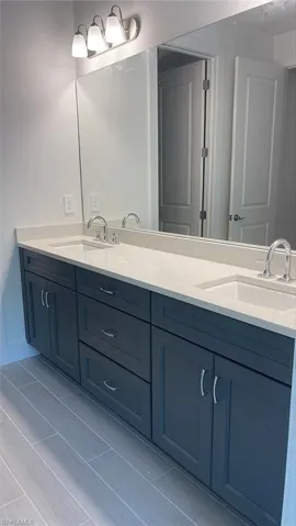 Primary bathroom dual-sinks with lovely quartz countertops and soft-close cabinets and drawers