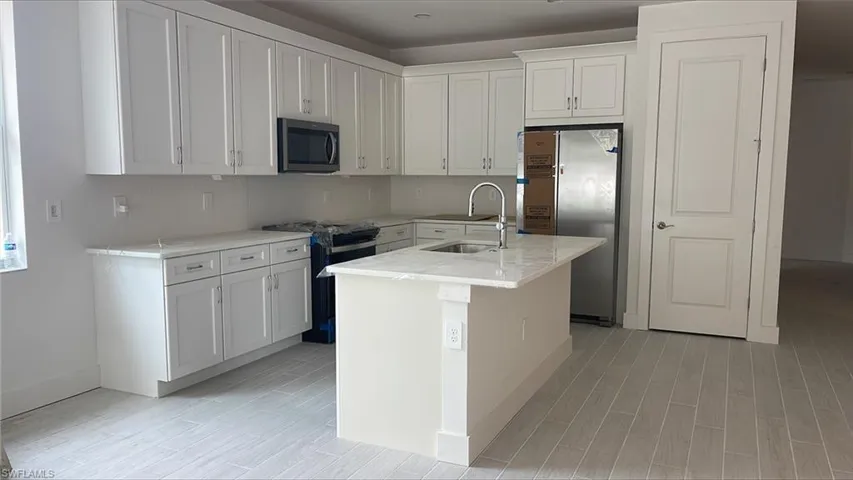 Chef's kitchen with lovely quartz countertops, soft-close cabinets and drawers, Whirlpool appliances including range microwave, gas oven, 36" side-by-side refrigerator, and dishwasher