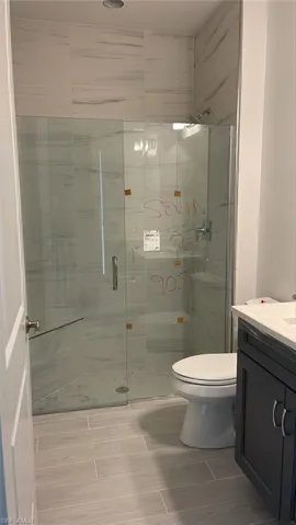 Guest bathroom featuring walk in shower, vanity, and toilet