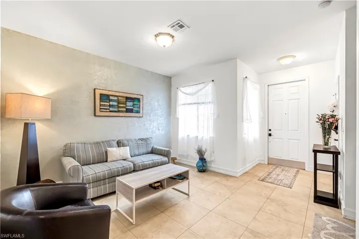 Living area featuring light tile patterned floors and baseboards