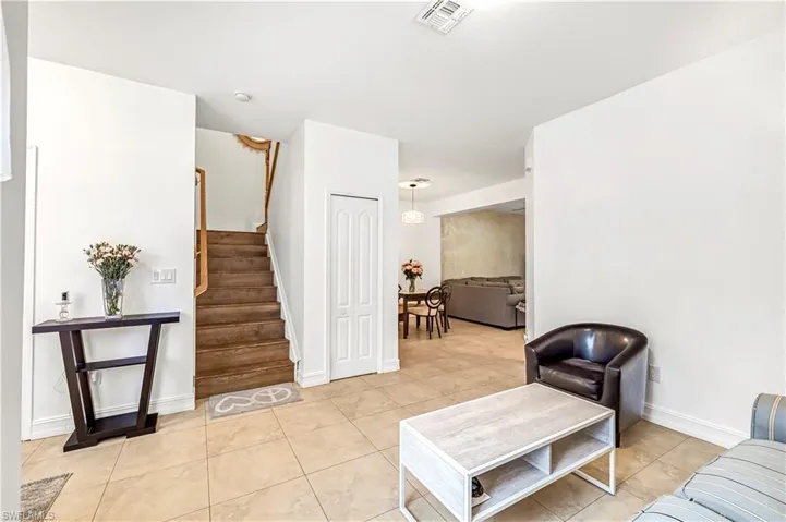 Living area with stairway and light tile patterned floors
