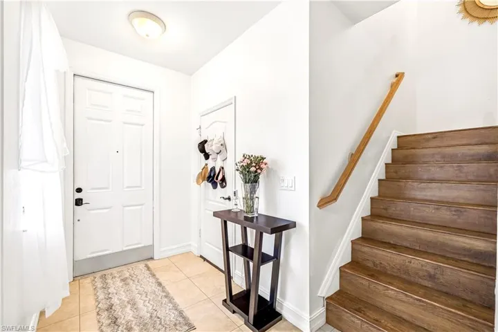 Entryway featuring light tile patterned flooring and stairway