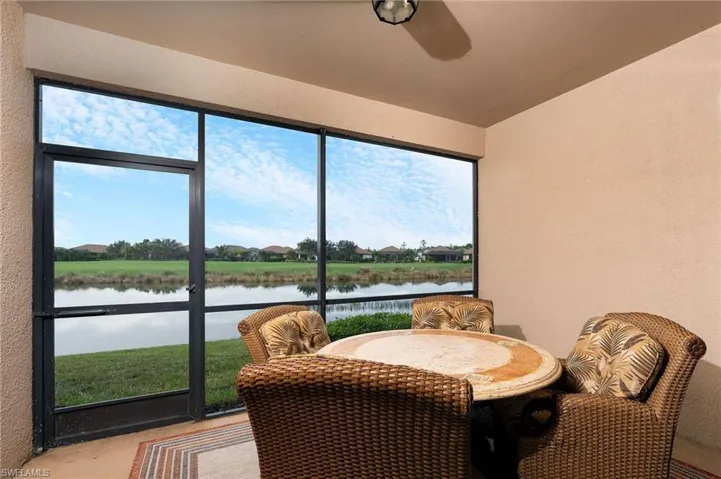 Waterfront lanai featuring expansive black-framed glass doors and windows showcasing lake and landscape vistas