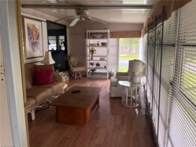 Living room featuring dark hardwood / wood-style floors, ceiling fan,